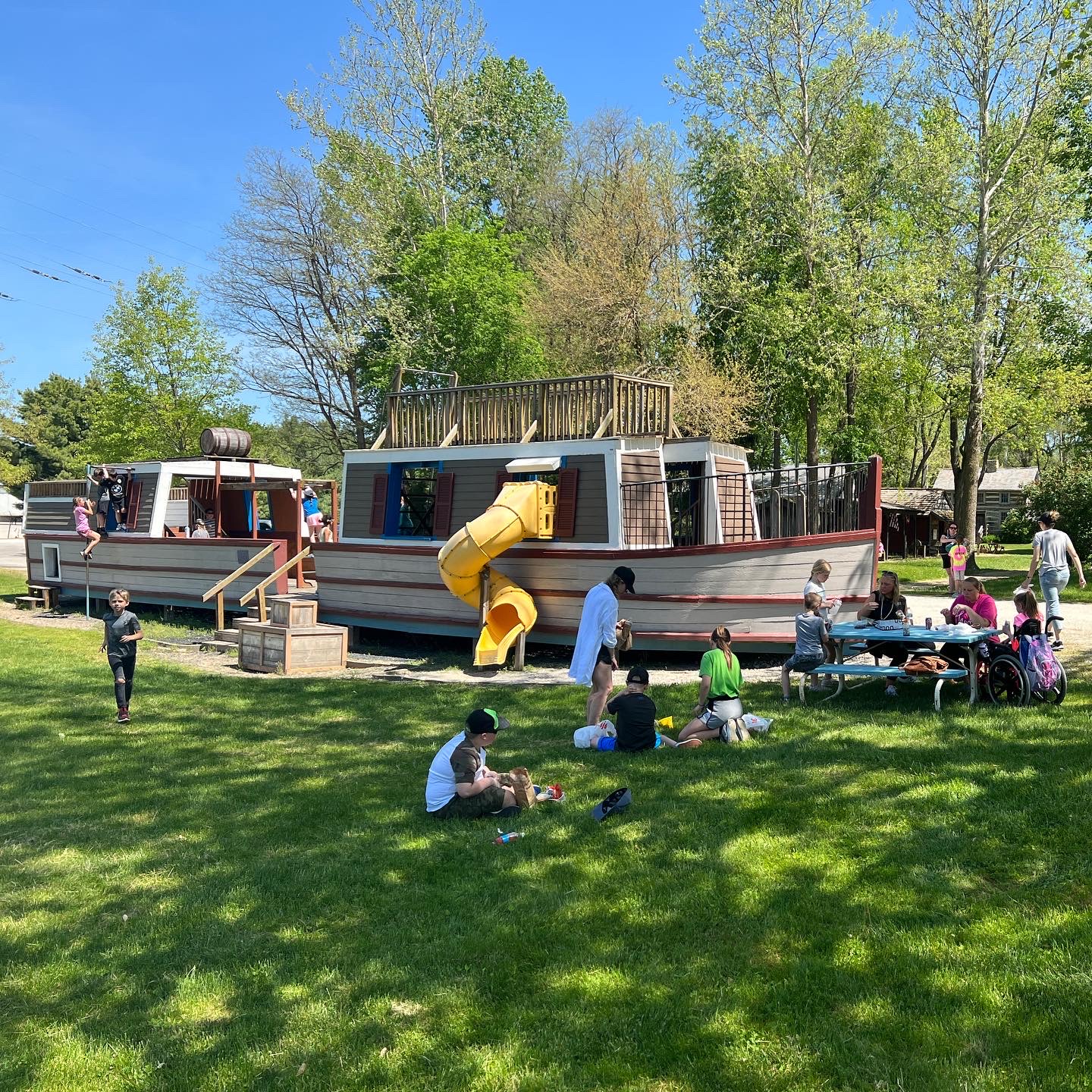 A group plays on the replica canal boat playground and enjoys a picnic