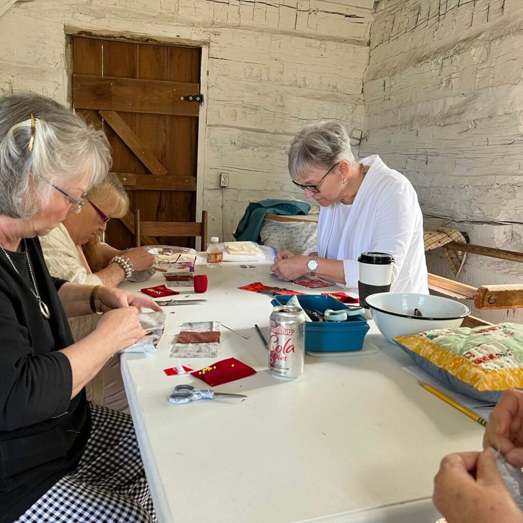 Students work on hand quilting projects in the Fouts House at Canal Park.