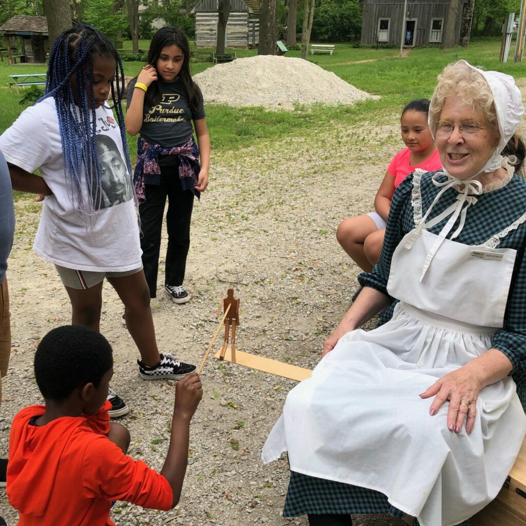 A volunteer plays games with children at Wabash & Erie Canal Park.