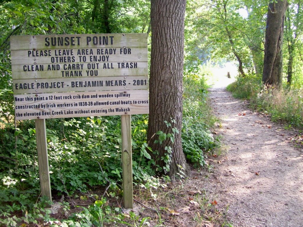 A wooded trail with a wayfinding sign, on the VanScoy Towpath Trail in Delphi.