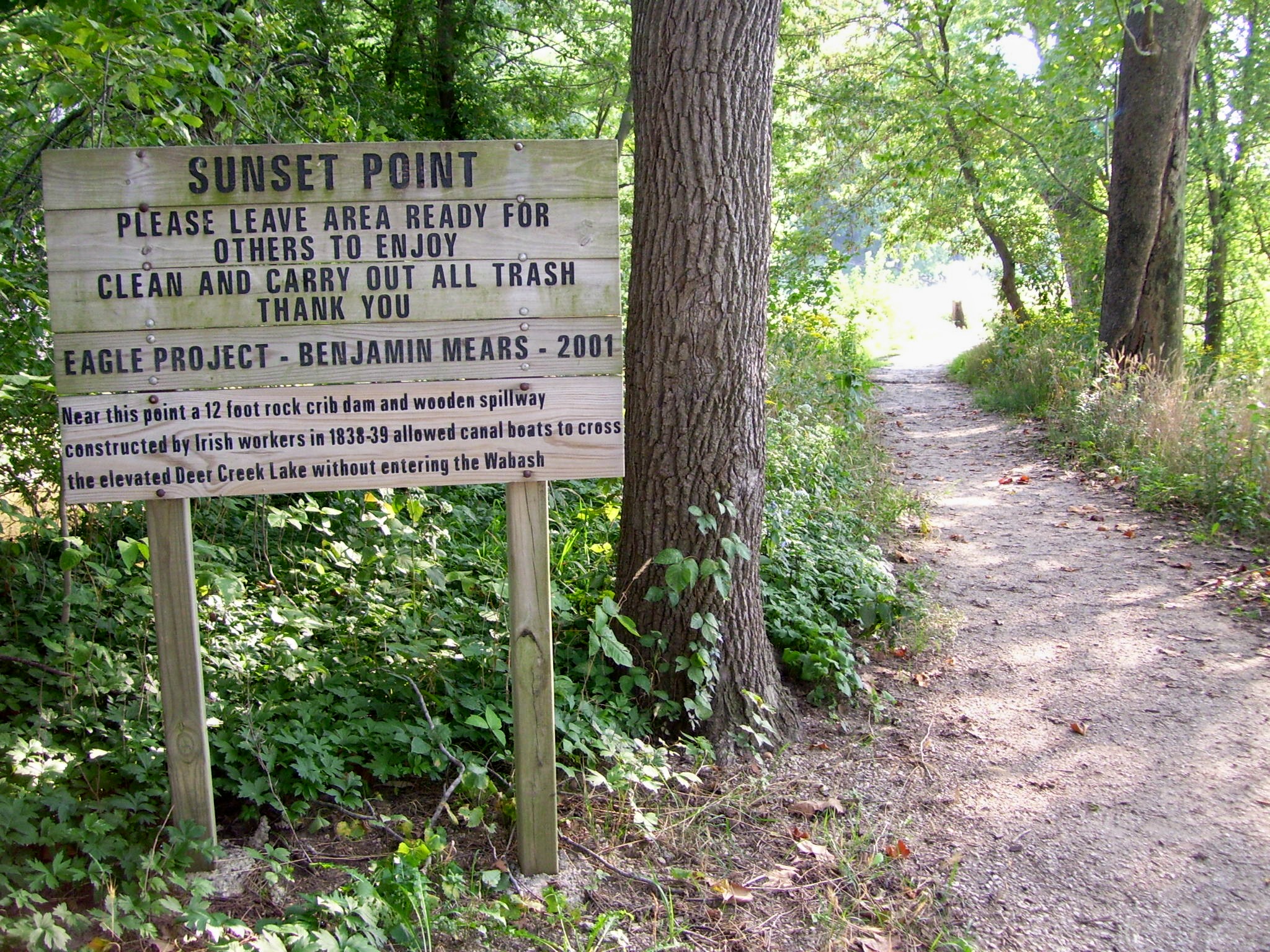 A wooded trail with a wayfinding sign, on the VanScoy Towpath Trail in Delphi.